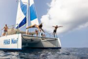 2 people jumping of trimaran in Hawaiʻi during a snorkeling tour