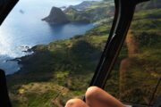 woman sitting in A helicopter crossing the Maui coastline with Haleakala on the horizon